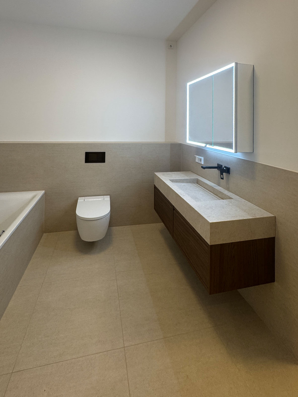 Saniertes Bad mit Waschtisch und Wand-WC in einem Berliner Reihenhaus