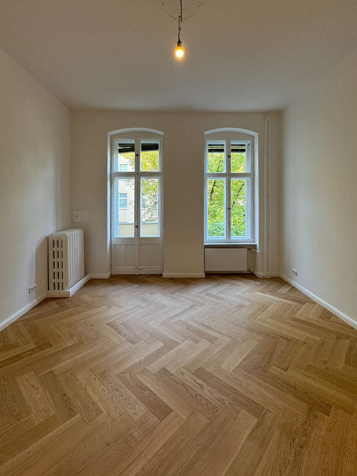 Saniertes Zimmer mit Parkett und zwei Fenstern in einer Altbauwohnung am Rüdesheimer Platz, Berlin (PLZ 14197)